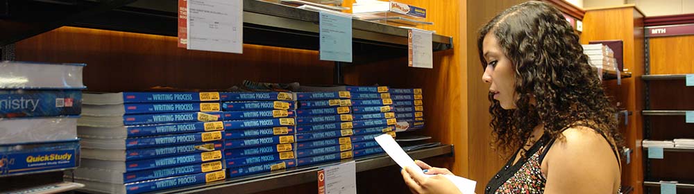 Student finding books in the campus bookstore
