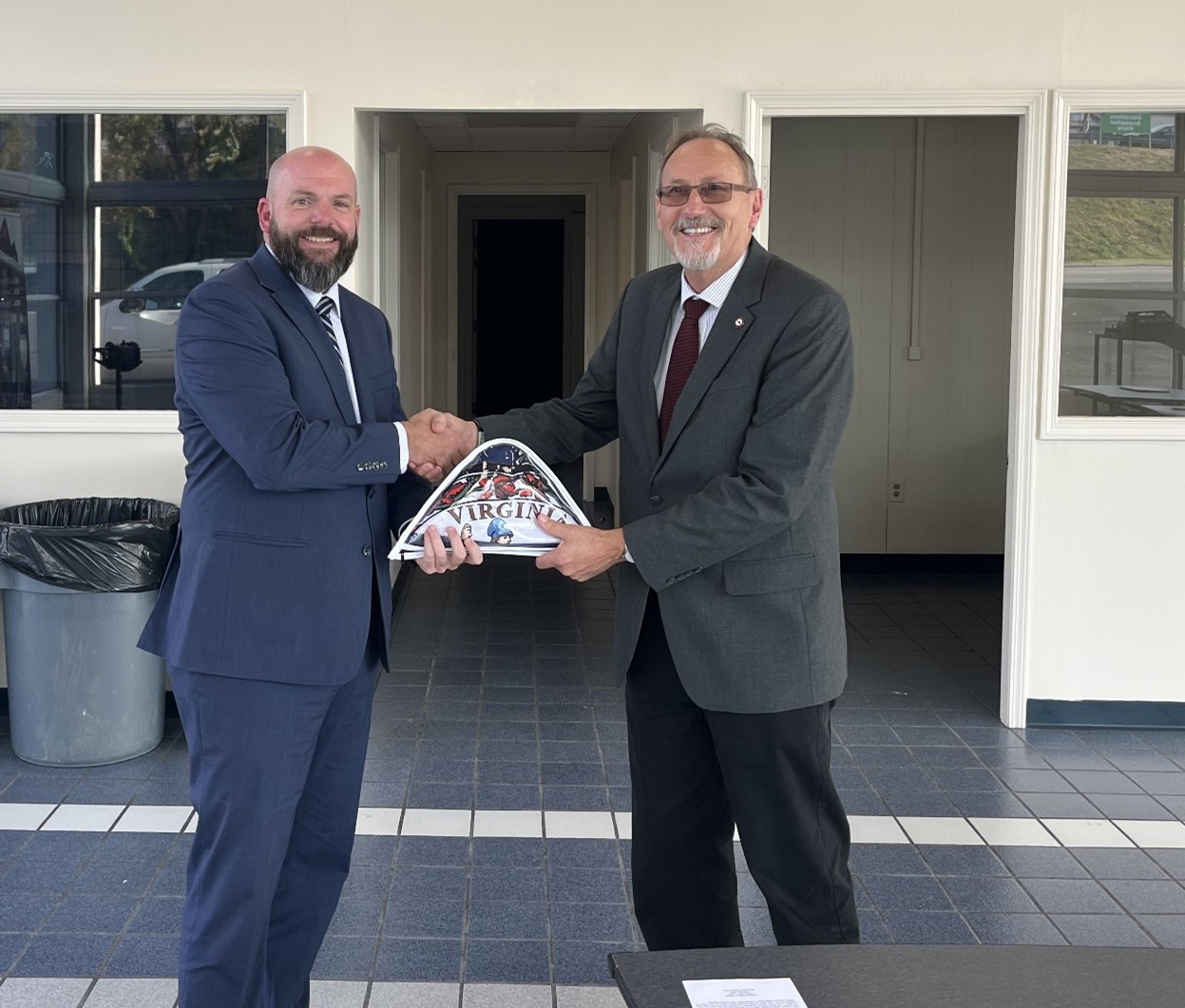 Virginia Delegate Jed Arnold, R -  46th District (Grayson, Pulaski (part), Smyth, and Wythe Counties), recently presented Wytheville Community College (WCC) President Dr. Dean Sprinkle with the state flag of Virginia to be displayed at WCC’s newest workforce education and training center, WCC WEST (Workforce, Education, & Skills Training). 
“WCC extends a heartfelt thank you to Delegate Arnold for the generous gift of the state flag to commemorate the opening of WCC WEST. Your support plays a vital role in the success of these workforce development students,” said Dr. Sprinkle. “We will display the flag proudly inside the new facility.” 
WCC celebrated the opening of WCC WEST on October 3, 2024, with a ribbon-cutting ceremony co-hosted by the Smyth County Chamber of Commerce. 
The facility in Marion, VA, enhances WCC’s capacity to provide much-needed workforce training in high-demand skilled trades in Smyth County and the western portion of the college’s service area.
WCC WEST currently offers an automotive training program and a welding program and plans to expand into additional skilled trades. The center is designed to provide hands-on training that meets the growing workforce demands of the region. 
Pictured: (L-R) Delegate Jed Arnold and Dr. Dean Sprinkle