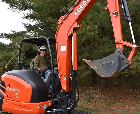 Student using backhoe as part of underground power program